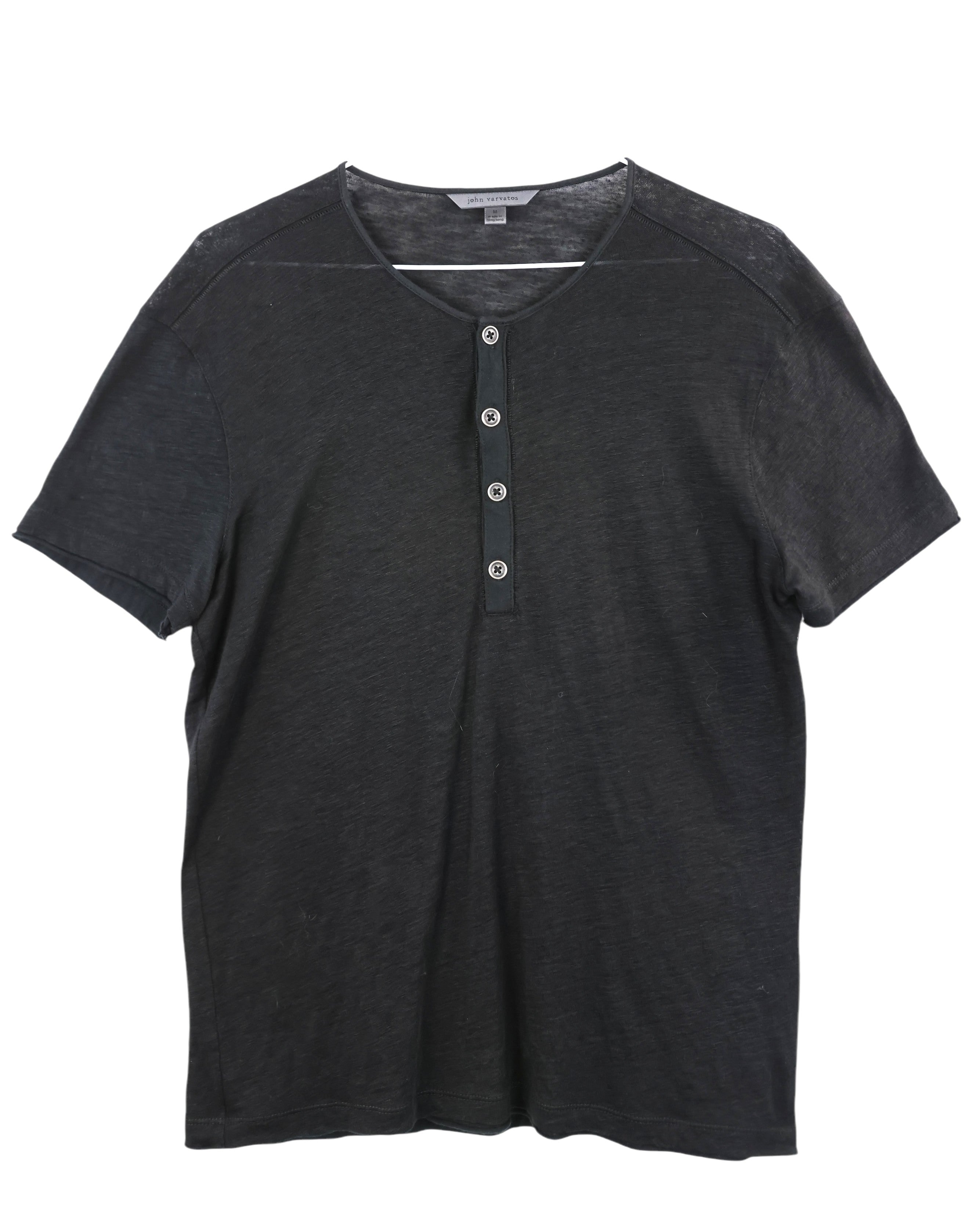 Black short-sleeve henley shirt on a white background. John Varvatos washed black Henley T-shirt; slub cotton jersey with 4-button placket, raw-edge neckline, short sleeves, slim-relaxed fit. John Varvatos Henley tee in washed black. Crafted from soft slub cotton with a four-button placket and subtle raw edges for that signature JV rock vibe. Perfect solo or layered under leather.