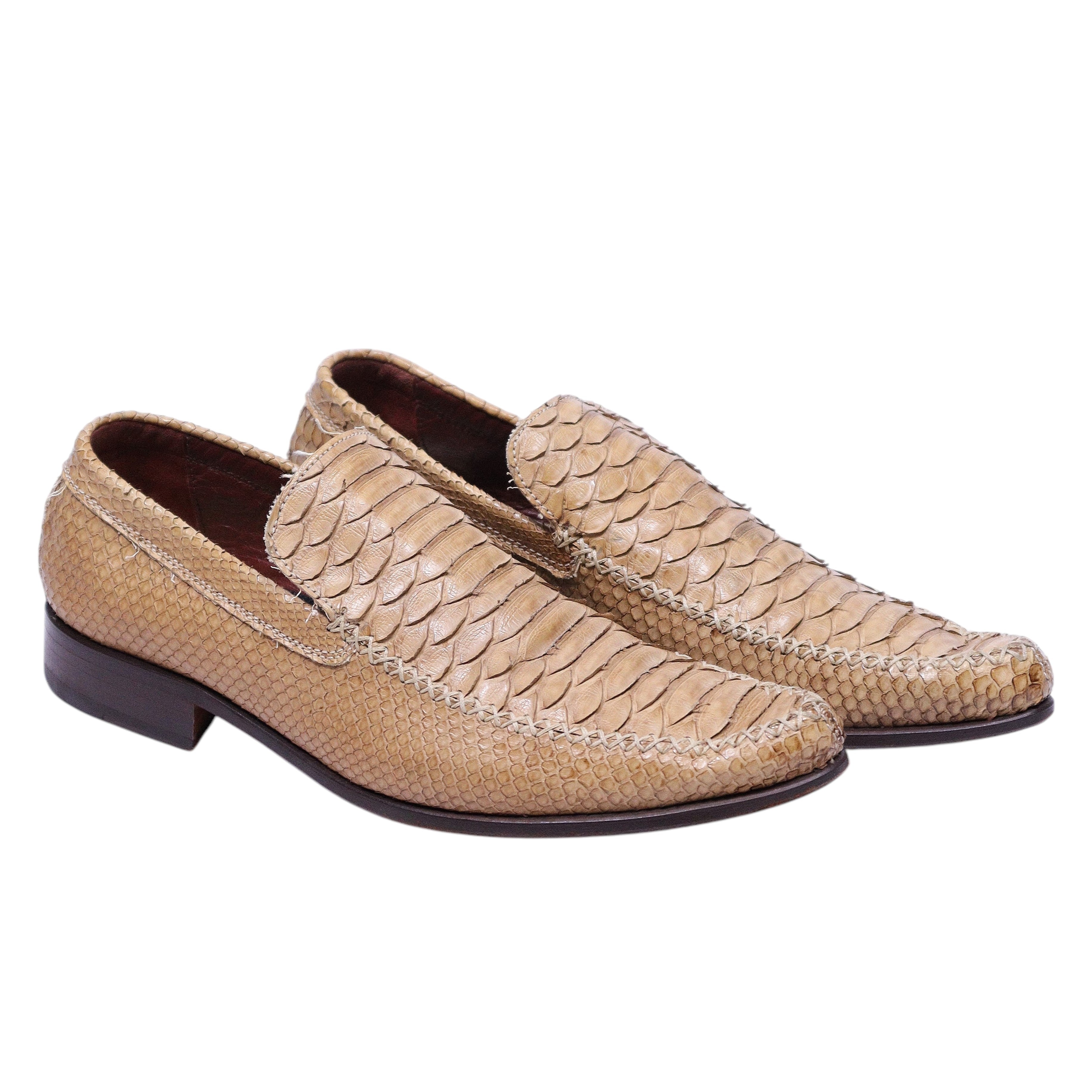 A pair of beige python leather loafers by Roberto Cavalli, displayed against a white background. Roberto Cavalli beige python-skin loafers with scaled vamp, slip-on design, almond toe, leather lining, and low stacked heel.