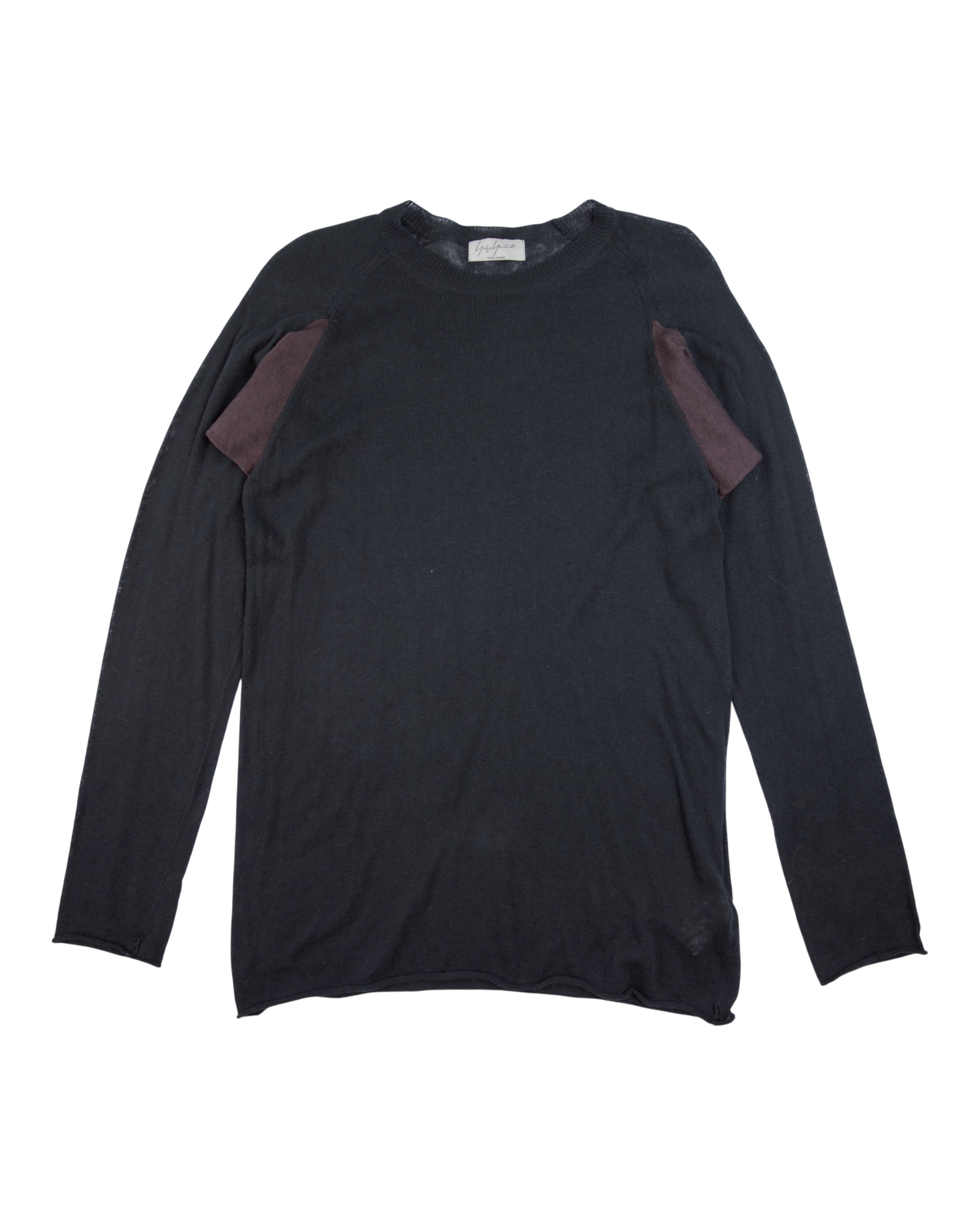 Black long-sleeve shirt with purple accents on a white background. Yohji Yamamoto black long-sleeve crewneck knit top featuring contrasting burgundy fabric insets at the shoulders; minimalist design with deconstructed detailing and soft draped fit; lightweight wool or cotton blend texture; avant-garde Japanese craftsmanship expressing understated elegance and contemporary urban edge.