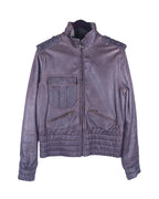 A brown Dolce & Gabbana goatskin leather jacket with a mandarin collar, zipper details, and a quilted design on the lower section. Dolce & Gabbana dark plum/brown goatskin leather jacket; stand collar, studded epaulettes, zip front, flap chest pocket with twin slanted zip pockets, quilted/smocked hem and cuffs; antique-brass hardware; regular fit, unisex; great with denim, tees, boots; style: moto, military, rocker, Y2K; brand context: Italian luxury house, made in Italy.