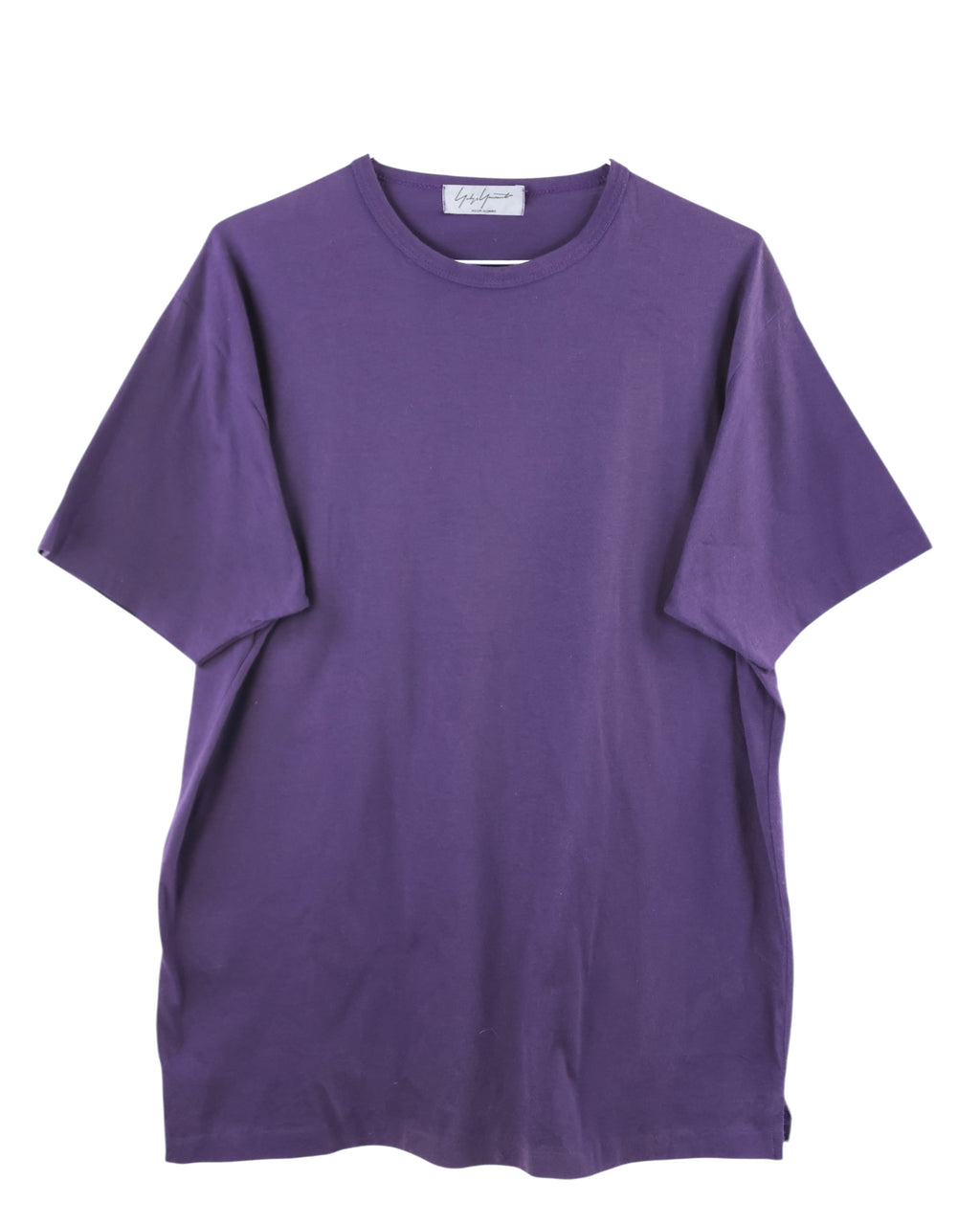 Purple t-shirt on a white background. Yohji Yamamoto deep purple oversized short-sleeve T-shirt; smooth midweight cotton with relaxed silhouette and minimal seaming; subtle Japanese avant-garde aesthetic combining simplicity, volume, and refined craftsmanship; timeless piece blending modern artistry with understated luxury streetwear appeal.
