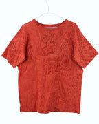 Red t-shirt on a white hanger against a white background. Yohji Yamamoto bold red short-sleeve T-shirt; luxurious silk-blend fabric with distinctive crinkled texture and relaxed oversized silhouette; minimalist neckline and Japanese avant-garde tailoring highlighting artistic imperfection and organic movement; elevated modern essential combining texture, form, and understated luxury.